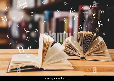 Open books with letters flying out of it in library Stock Photo
