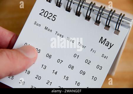 Close up view of May 2025 Calendar on wooden desk background. Calendar concept. Stock Photo