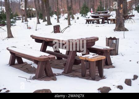 Picnic table and bench furniture under snow witnout people in winter forest in Siberia Stock Photo