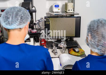Doctor using IVF micromanipulator with Petri Dish on it for insemination of the egg in the laboratory of the in vitro fertilization. Stock Photo