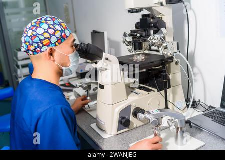 Doctor using IVF micromanipulator with Petri Dish on it for insemination of the egg in the laboratory of the in vitro fertilization. Stock Photo