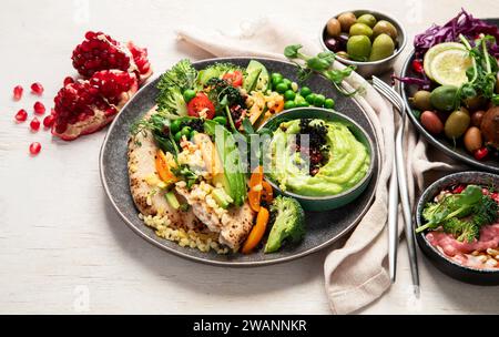 Vegan tasty hummus, herb hummus, beetroot hummus on a light wood background. Stock Photo