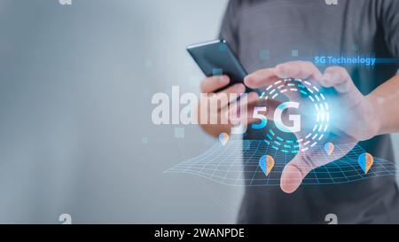 Close-up of human hand holding smartphone and pointing at 5G hologram, 5G wireless network system, 5G network concept, High speed mobile internet, New Stock Photo