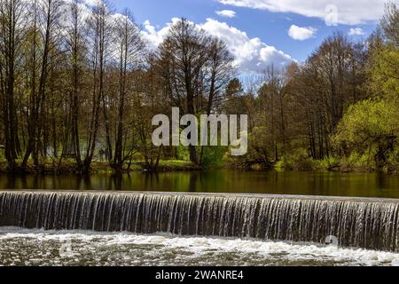 waterfall against the background of the forest and sky. Small waterfall on a river in the forest. Stock Photo