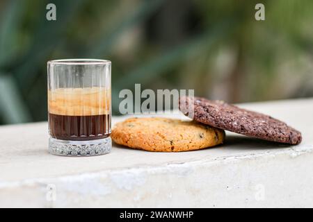 Chocolate cookie and Coffee in glass cup on rustic wooden background. Close up. Stock Photo