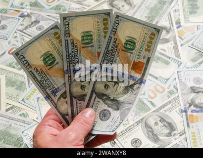 A hand holds three hundred dollar US dollar bills. Stock Photo