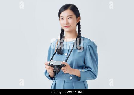 Full isolated studio picture from a young and beautiful woman with camera Stock Photo