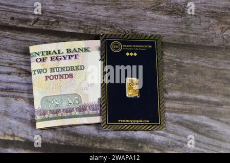 Cairo Egypt January 2 2024 Gold Era And SAM Precious Metal 24K Karat   Cairo Egypt January 2 2024 24k Karat Btc Bullion Trading Center Pure Yellow Gold Of Bars And Sovereign Coin And A Stack Of Egyptian Money Banknote 2wapa12 