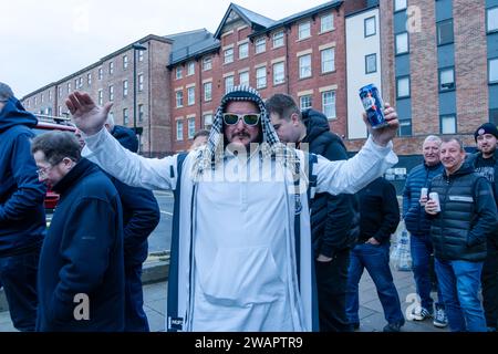 Newcastle upon Tyne, UK. 6th January 2024. Newcastle United fans queue at St James' Park, to get on busses to take them to the away match in Sunderland, in the Wear-Tyne derby FA Cup 3rd Round. Credit: Hazel Plater/Alamy Live News Stock Photo