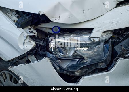 close-up of an accident damage at a headlamp and fenders of a white car Stock Photo