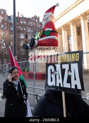 Manchester, UK. 6th Jan 2024. Manchesters Santa still in place as Protesters In Manchester UK protest against the war in Gaza. Palestinian protest in central Manchester. UK. Over two thousand protesters gathered at St Peter's Square calling for a ceasefire. They then marched through the city centre. Police guarded outlets that the protesters said had links with Israel including Barclays Bank and Starbucks Coffee. Protesters waved flags and carried placards with slogans against the war. Manchester UK. Picture: garyroberts/worldwidefeatures.com Credit: GaryRobertsphotography/Alamy Live News Stock Photo