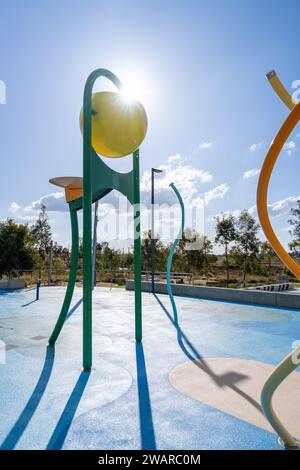 A vibrant outdoor water park with a playground area featuring several pieces of equipment, perfect for kids of all ages to have fun in the sun Stock Photo