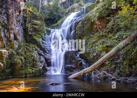 A beautiful waterfall called: kamienczyk shot from close up,with a log in the water. Shot in the mountains of a city named szklarska poreba in Poland Stock Photo