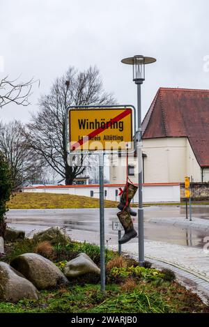 Rubberboots hang from a sign at the exit of the town of Winhoering in Germany to protest against the latest tax measures from the government  affectin Stock Photo