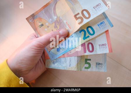 Woman's hand holding various euro banknotes Stock Photo