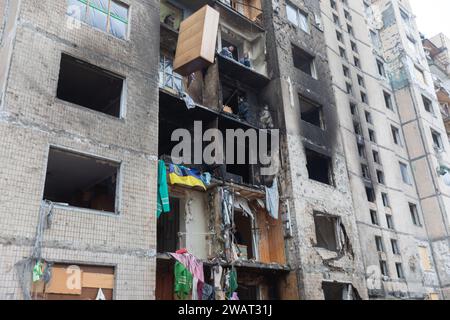 The facade of a building after a missile attack by Russian troops. Broken windows and traces of fire are seen. Volunteers throw damaged items out of the windows of the building A multi-storey residential building in the Solomenskiy district of the capital suffered damages as a result of a massive russian missile strike on Kyiv on 2 January. The building suffered the worst damages among other residential buildings.And many residents were injured and hospitalised. Rescuers and volunteers help in removing the rubbish and remnants from the damaged building. (Photo by Mykhaylo Palinchak/SOPA Imag Stock Photo