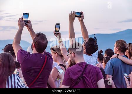 Large tourist crowd on Piazzale Michelangelo enjoying sunset over Florence, Italy Stock Photo