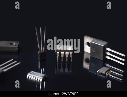 Electronic semiconductor components. Integrated circuit and transistors with reflections on a black. Electronic industry background. Stock Photo
