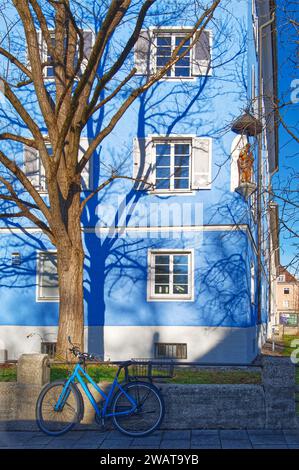 Blue bicycle in the front of a blue house with an ornament. Light and shadows Stock Photo