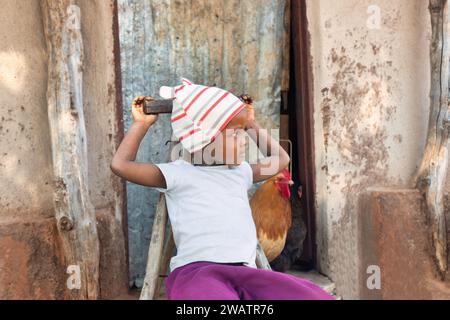 Outdoor portrait of a cute black baby boy sited on a bench Stock