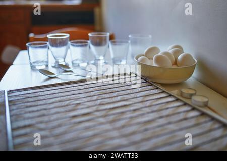 Using food coloring to dye Easter eggs at home. Painting colorful eggs for Easter hunt. Getting ready for Easter celebration. Family traditions. Stock Photo