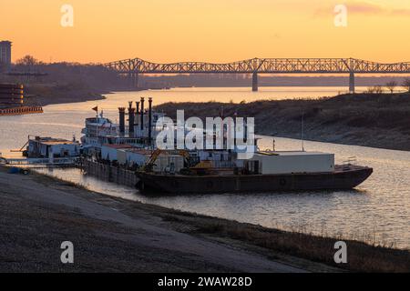 Memphis, Tennessee, riverfront steamboats along the Mississippi River at sunset near the Memphis-Arkansas Bridge and parallel Harahan Bridge. (USA) Stock Photo