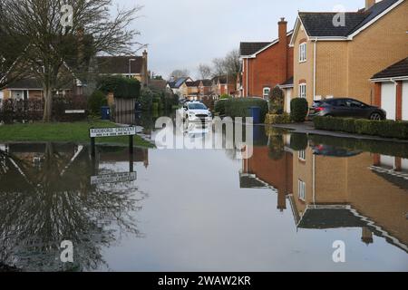 Brampton, UK. 06th Jan, 2024. Homes line Centenary Way as flood water covers the road as the River Great Ouse bursts its banks at Brampton. Flood alerts remain in place as waters continue to rise in the east of England following storm Henk. Main rivers the River Great Ouse and the River Nene have burst their banks and spilled onto the surrounding countryside and with drains full to capacity they are backing up in residential areas. Credit: SOPA Images Limited/Alamy Live News Stock Photo