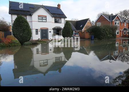 Brampton, UK. 06th Jan, 2024. Homes line Centenary Way as flood water covers the road as the River Great Ouse bursts its banks at Brampton. Flood alerts remain in place as waters continue to rise in the east of England following storm Henk. Main rivers the River Great Ouse and the River Nene have burst their banks and spilled onto the surrounding countryside and with drains full to capacity they are backing up in residential areas. Credit: SOPA Images Limited/Alamy Live News Stock Photo