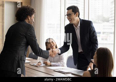 Two cheerful Arab project managers men shaking hands Stock Photo