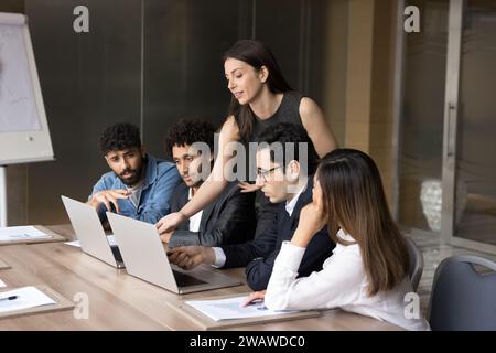 Confident busy coach woman training diverse team of new employees Stock Photo
