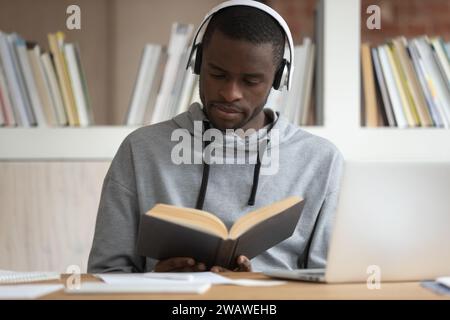 Concentrated african American guy read book preparing for exam Stock Photo