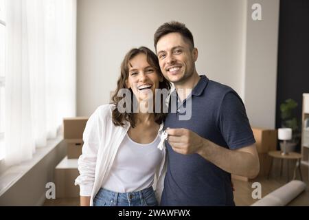 Couple of new home owners holding keys from new flat Stock Photo