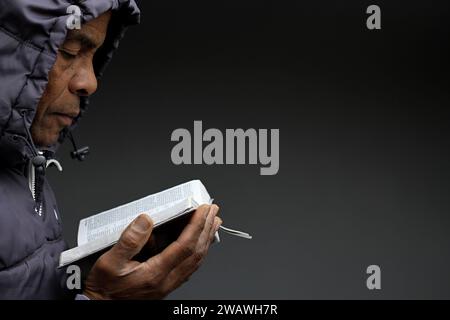 praying to god for forgiveness Caribbean man praying with grey black background with people stock image stock photo photo Stock Photo