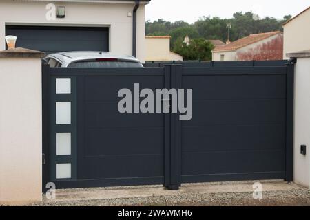 double portal dark entrance large metal gate high grey fence on suburb street house door Stock Photo