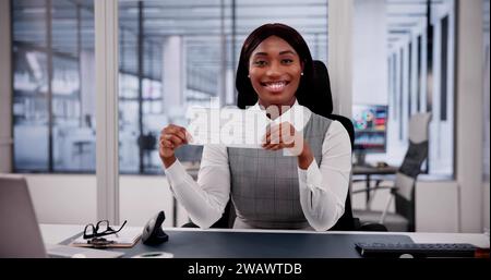 Business Woman Holds Checkbook, Examining Paycheck and Cheque Stock Photo