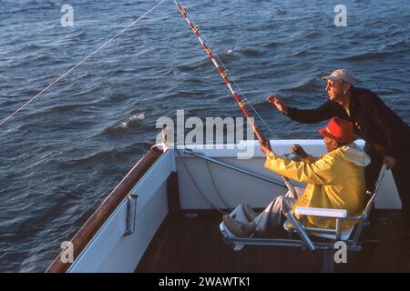 Legendary monster fisherman Frank Mundus takes a wealthy man on a fishing expedition in Montauk, Long Island, NY. Mundus is believed to be the model for the character Quint in the epic film, Jaws. Stock Photo