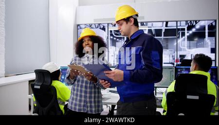 Factory Engineers In Helmets. Checking Industrial Facility Stock Photo