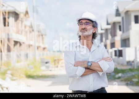 Portrait senior male business man land development investor standing confident in under construction site. Professional real estate project manager ma Stock Photo