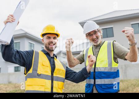 Young man worker construction engineer male working cooperate with senior project supervisor in construction site happy smile. Stock Photo