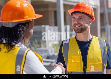 Happy construction engineer handshaking. Builder man enjoy working job deal contact with partner team smile together. Stock Photo