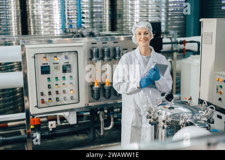 portrait happy women staff worker in drinking water plant work control water quality purification test process. Stock Photo