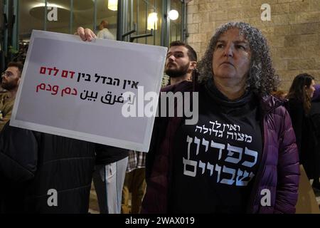 A left-wing Israeli activist holds a sign that reads 'There is no difference between blood and blood' during an anti-war protest calling for a ceasefire and diplomatic solution to the ongoing Israel-Hamas war on January 6, 2024 in Jerusalem.  Israel Stock Photo