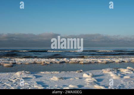 Winter's story unfolds in hues of gold along the icy embrace of the coastal horizon. Stock Photo