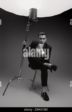 elegant model man in black suit in photostudio. black and white Stock Photo