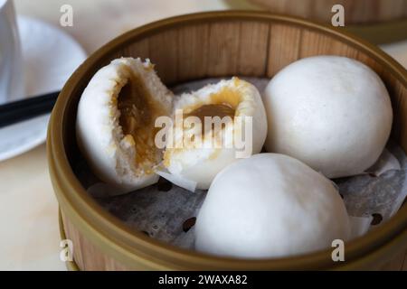 Cantonese dim sum - sweet tasting lin yong (or yung) bao buns filled with lotus seed paste - served in a bamboo steamer, UK Stock Photo