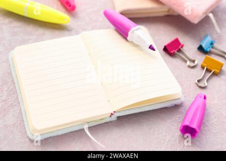 Blank open notebook, markers and binder clips on light background, closeup Stock Photo