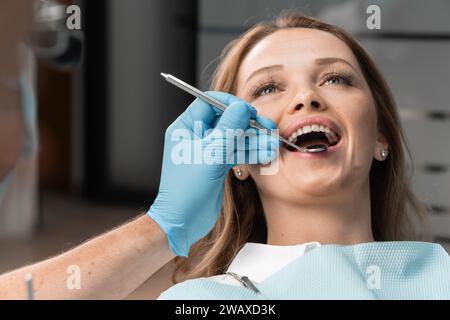 Like a true expert, the doctor examines each tooth in detail, assessing the condition of the enamel, gums, and other aspects of dental health. The Stock Photo