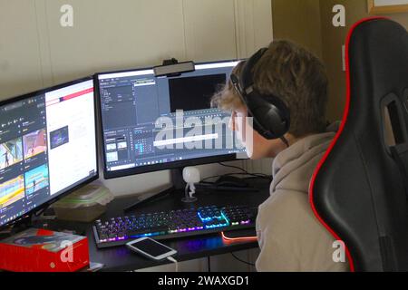 Dublin, Ireland - January 3rd 2024: A close up photo of a young boy video editing at his desk on his PC. Stock Photo