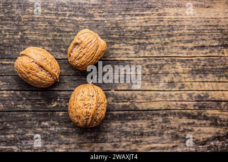Three walnuts on the wooden table. Top view. Stock Photo