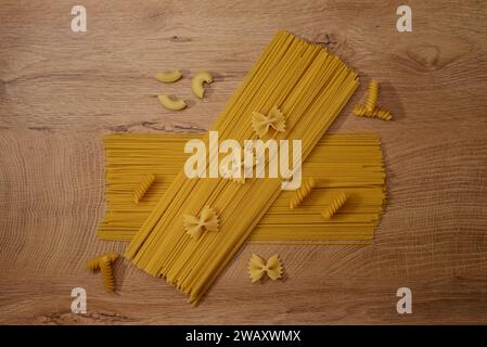 Raw spaghetti and pasta on wooden board Stock Photo